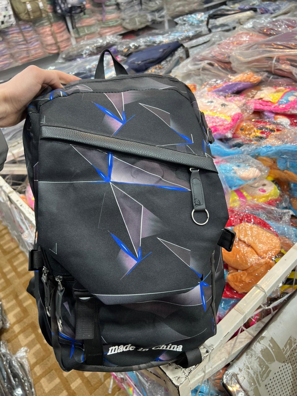 Black geometric backpack showing spacious interior capacity and practical compartment design