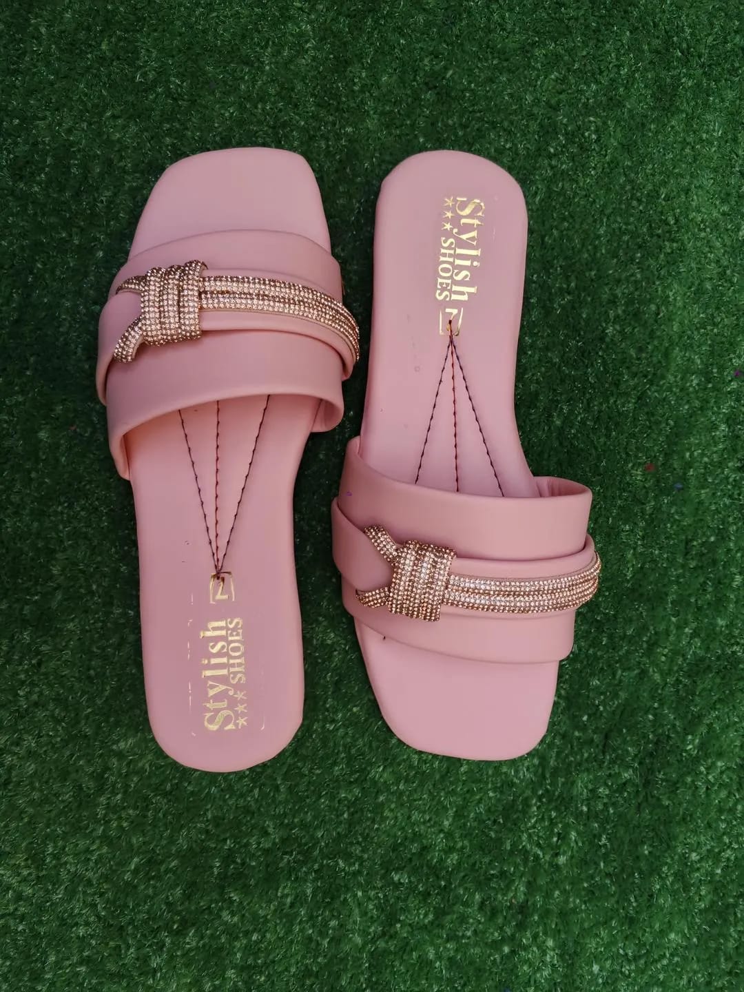 Pink women's flat sandals top view with decorative buckle straps