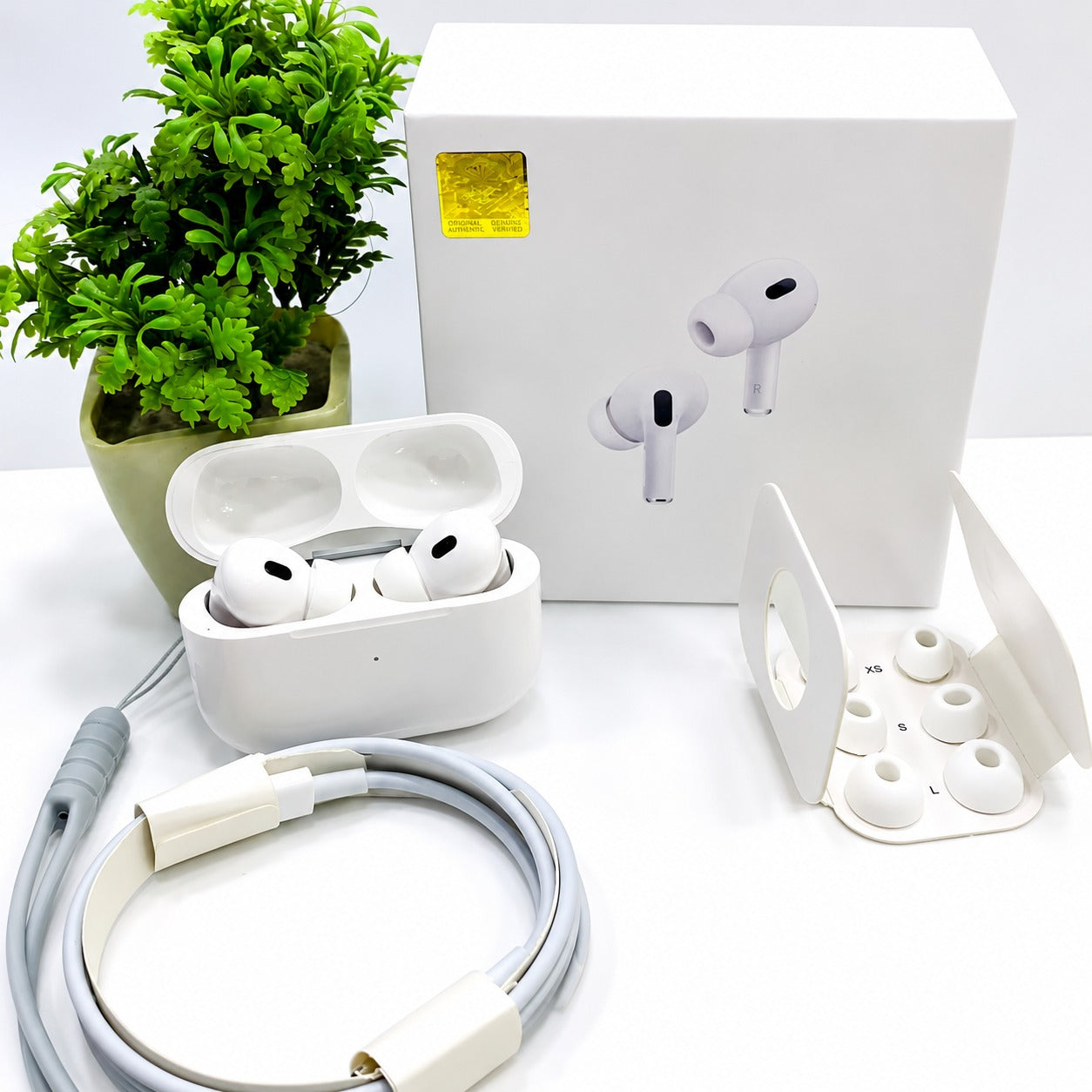 White Bluetooth wireless earbuds with charging case and USB cable
